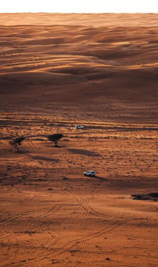 好看的行驶在荒漠的几辆SUV，一望无际的荒漠风景手机壁纸图片下载