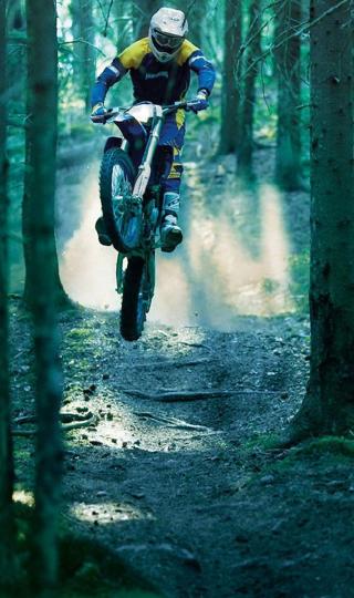 树林中跳跃的摩托车手机背景下载