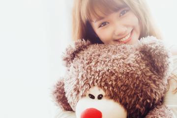 抱着玩具熊的可爱微笑女孩图片
